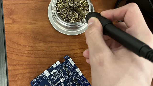 Soldering a CubeSat solar power board on a lab bench